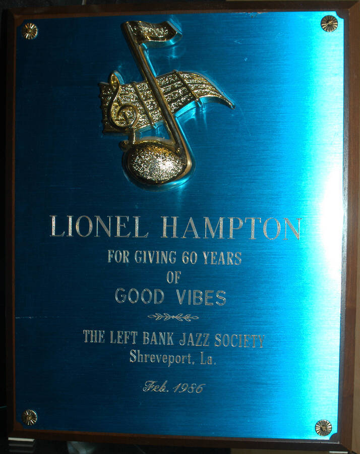 Plaque. 10"x8" Wood finish plaque with blue engraved plate bearing musical theme To Lionel Hampton from the Left Bank Jazz Society, for giving 60 years of good vibes. Shreveport, LA. Feb. 1986