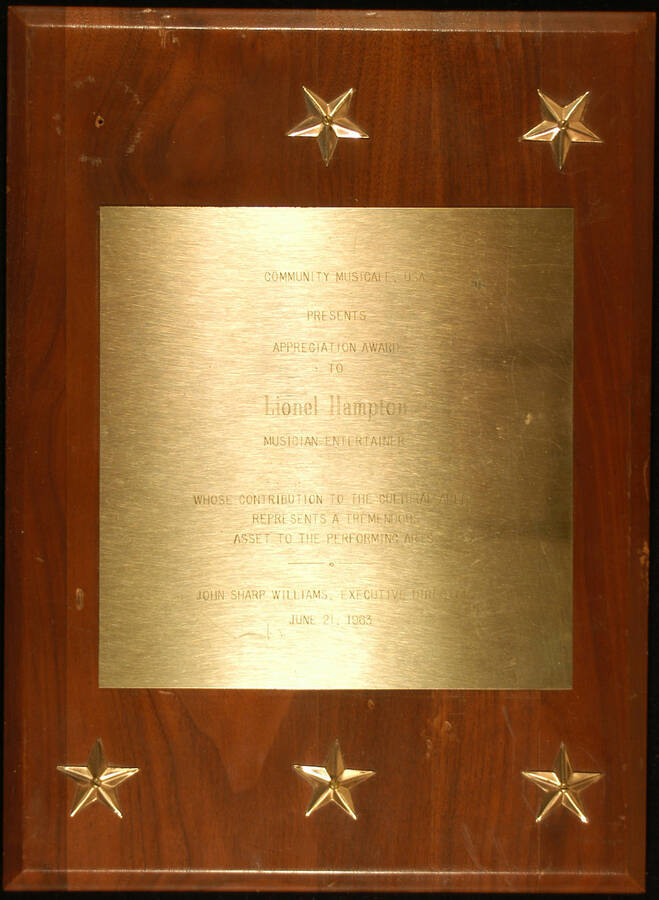 Plaque. 12 1/8"x9" Wood finish plaque with six stars and engraved plate Appreciation Award presented to Lionel Hampton by the Community Musicale, USA for his contribution to the cultural arena and performing arts. John Sharp Williams, Executive Director. June 21, 1963