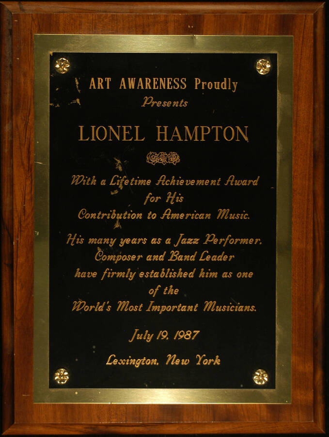 Plaque. 12"x9" Wood finish plaque with engraved double plate Lifetime Achievement Award presented to Lionel Hampton by Art Awareness for his contribution to American Music. Lexington, NY, July 19, 1987