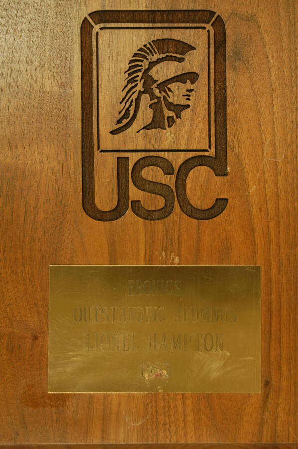 Plaque. 12"x9" Engraved wood finish plaque with USC theme and engraved plate Ebonics Outstanding Alumnus presented to Lionel Hampton by the University of Southern California. 1985