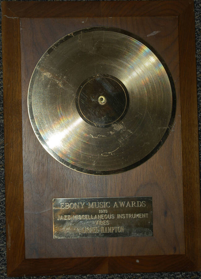 Plaque. 14"x10" Wood finish plaque with  gold recorder and engraved plate Ebony Music Awards, Jazz Miscellaneous Instrument Vibes presented to Lionel Hampton. 1975