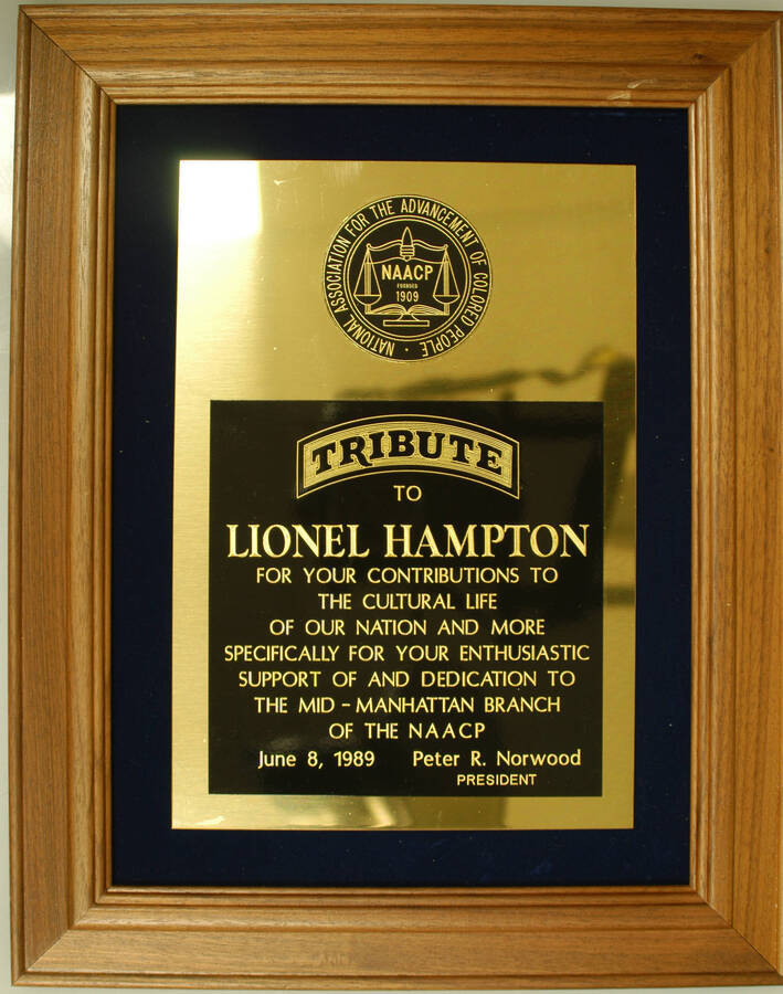 Plaque. 14 1/2"x11 1/2" Wood frame holding engraved double plate on blue velvet background To Lionel Hampton from the National Association for the Advancement of Colored People-NAACP for his enthusiastic support of and dedication to the Mid-Manhattan Branch of the NAACP.  June 8, 1989