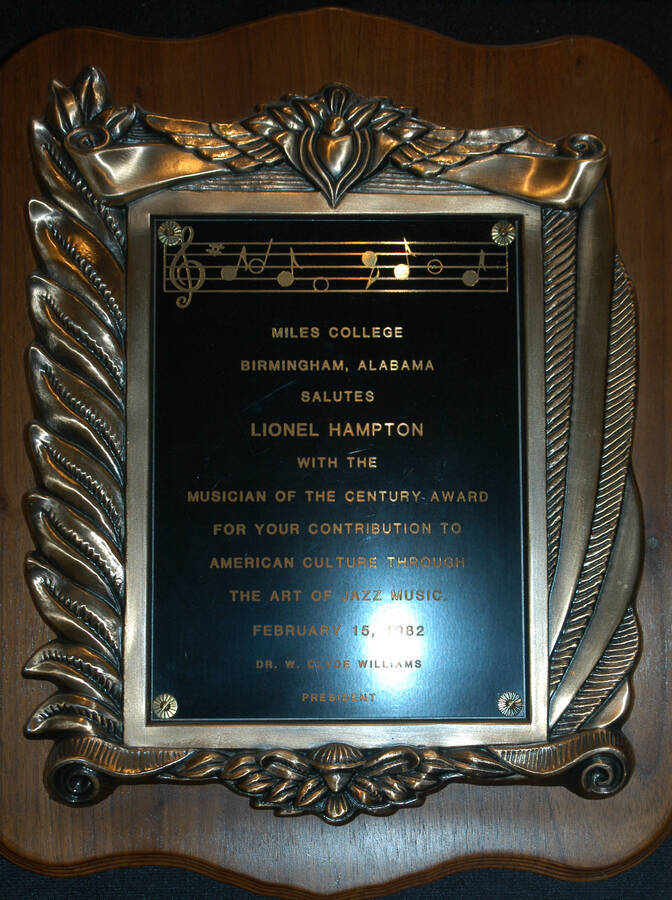 Plaque. 14"x11 1/2" Wood finish plaque with engraved plate inside casting Musician of the Century Award presented to Lionel Hampton by Miles College for his contribution to American Culture through the art of jazz music. W. Clyde Williams, President. Birmingham, AL, Feb. 15, 1982