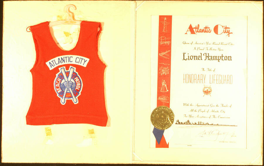 Certificate. 12 1/4"x9 1/4" Certificate with gold foil Seal of Atlantic City in a folder. Also a 9"x7" red beach patrol shirt in a hanger Atlantic City presents Lionel Hampton with the title of Honorary Lifeguard. (Signed by  Joseph Bradway, Jr., Mayor) Atlantic City, NJ, [1972–1976]