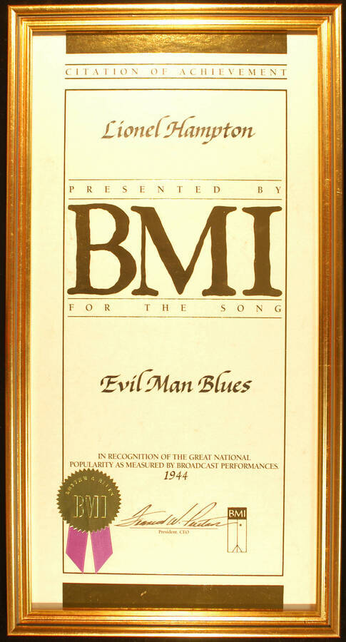 Framed Certificate. 20"x10" Certificate with gold foil seal and purple ribbon in an 21 1/4"x11 1/4" frame with glass Citation of Achievement presented to Lionel Hampton by BMI for the song Evil Man Blues in recognition of the great national popularity as measured by broadcast performances. 1944