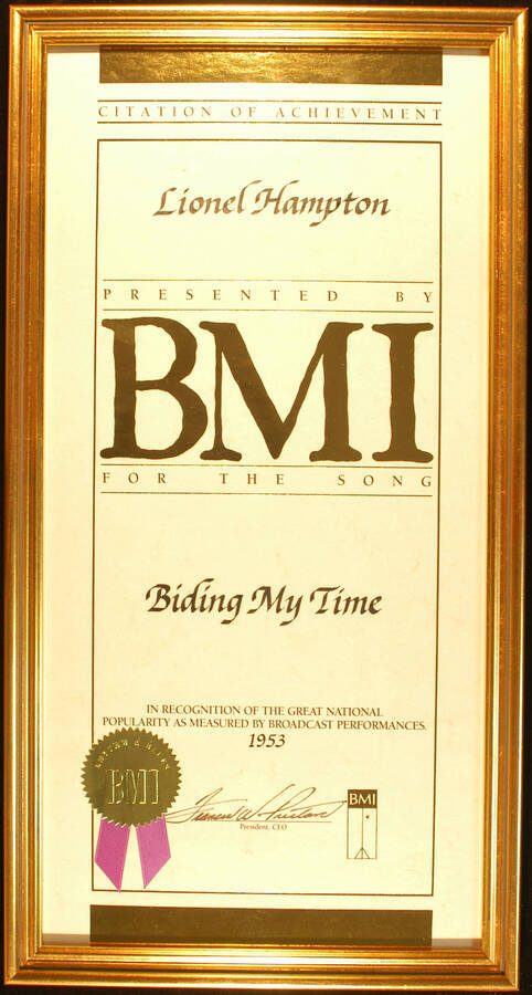 Framed Certificate. 20"x10" Certificate with gold foil seal and purple ribbon in an 21 1/4"x11 1/4" frame with glass Citation of Achievement presented to Lionel Hampton by BMI for the song Biding My Time in recognition of the great national popularity as measured by broadcast performances.1953