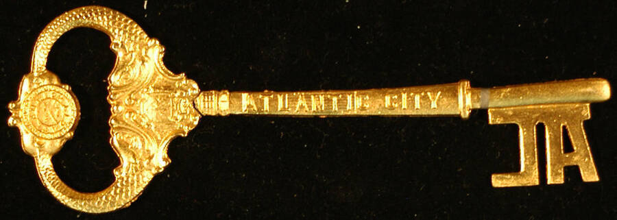 Key to the City. 2"x6" Gold coated metal key with a AL shaped tooth and a bow composed by two curved fish on each side with a coat of arms under their heads and a disc between the end of their tails that reads 'Atlantic City All the Time" Ceremonial key to the City of Atlantic City presented to Lionel Hampton. Atlantic City, NJ