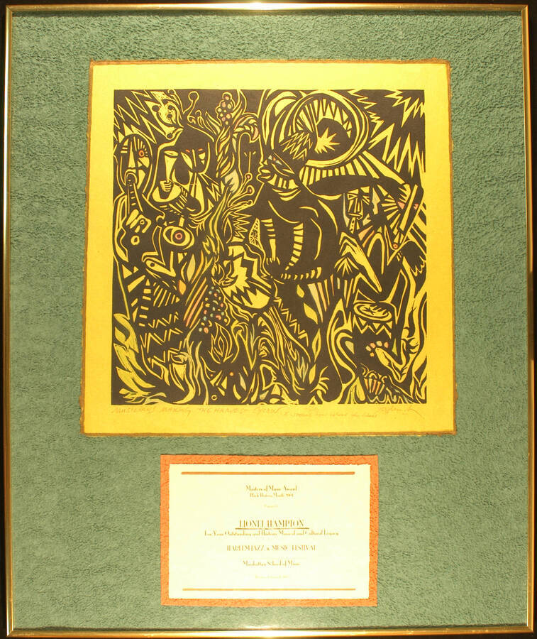 Plaque.  20 1/2"x24 1/4" Gold aluminum frame holding from top to bottom: a 14 1/2"x14 1/2' hand colored woodcut print entitled "Musicians Making the Harvest Grow" numbered "28/40" and signed "Ademola Olugebefola,"  and a dedication, on green background under glass Masters of Music Award Black History Month 2001 presented to Lionel Hampton for his outstanding and historic musical and cultural legacy. Harlem Jazz and Music Festival. Manhattan School of Music. Feb. 8 2001