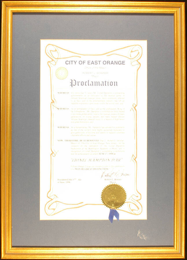 Framed Certificate. 19"x14" Gold frame holding a proclamation with gold foil seal and blue ribbon in blue mat under glass The City of East Orange proclaims June 17, 1998 as Lionel Hampton Day, on the occasion of the dedication of the Lionel Hampton Auditorium at the Washington Academy of Music. Robert L. Bowser, Mayor. East Orange, NJ, June 17, 1998