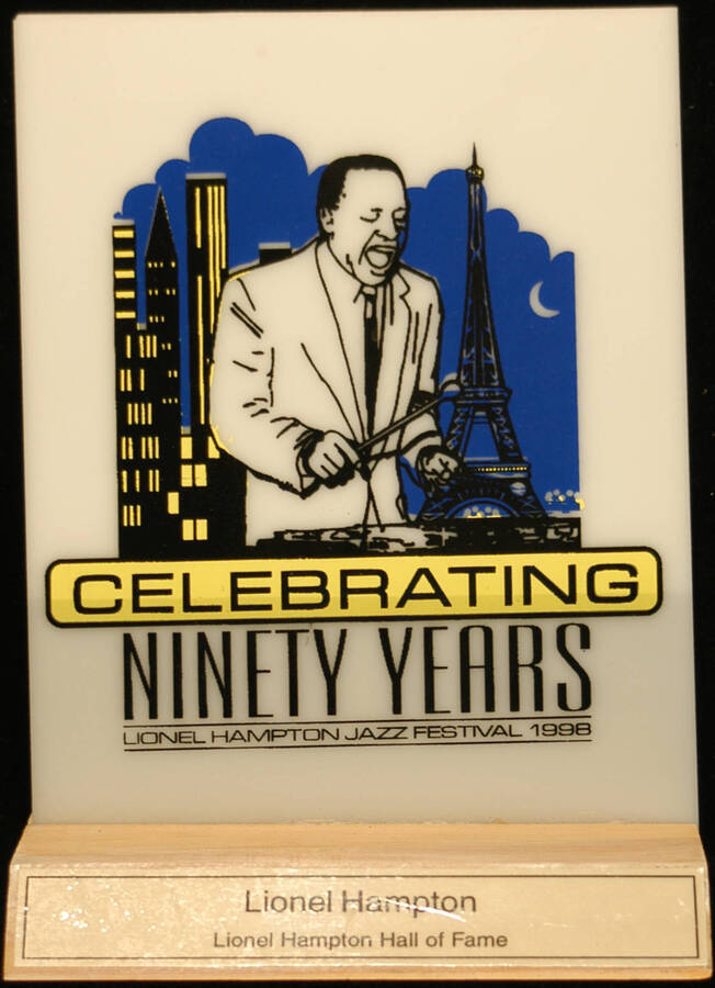 Plaque. 6 1/2"x5" Acrylic screen printed plaque on a 3"x5" wood base that reads "Lionel Hampton Hall of Fame" [University of Idaho] Lionel Hampton Jazz Festival celebrating ninety years. [Moscow, ID], 1998