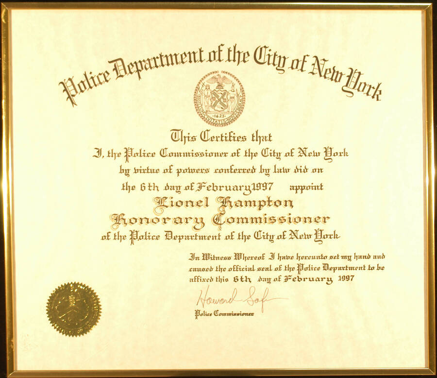 Framed Certificate. 13 1/2"x15 1/2" Gold aluminum frame holding a certificate with gold foil seal under glass Title of Honorary Commissioner presented to Lionel Hampton by the Police Department of the City of New York. Howard Safir, Police Commissioner. New York, NY, Feb. 6, 1997
