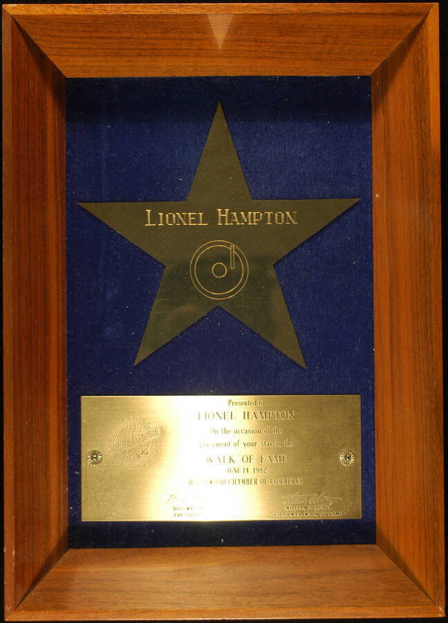 Plaque. 14"x10"x2 1/4" Wood frame holding a 7"x7" Star engraved plaque and a 3"x6 3/4" engraved plaque on blue velvet background To Lionel Hampton from the Hollywood Chamber of Commerce on the occasion of the placement of his star in the Walk of Fame. Bill Welsh, President and William F. Hertz, Chairman, Walk of Fame. Los Angeles, CA, June 14, 1982