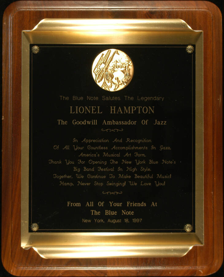 Plaque. 13"x10 1/2" Wood finish plaque with scroll  engraved double plate To Lionel Hampton from the Blue Note for opening the New York Blue Note's Big Band Festival in high style. New York, NY, Aug. 18, 1997