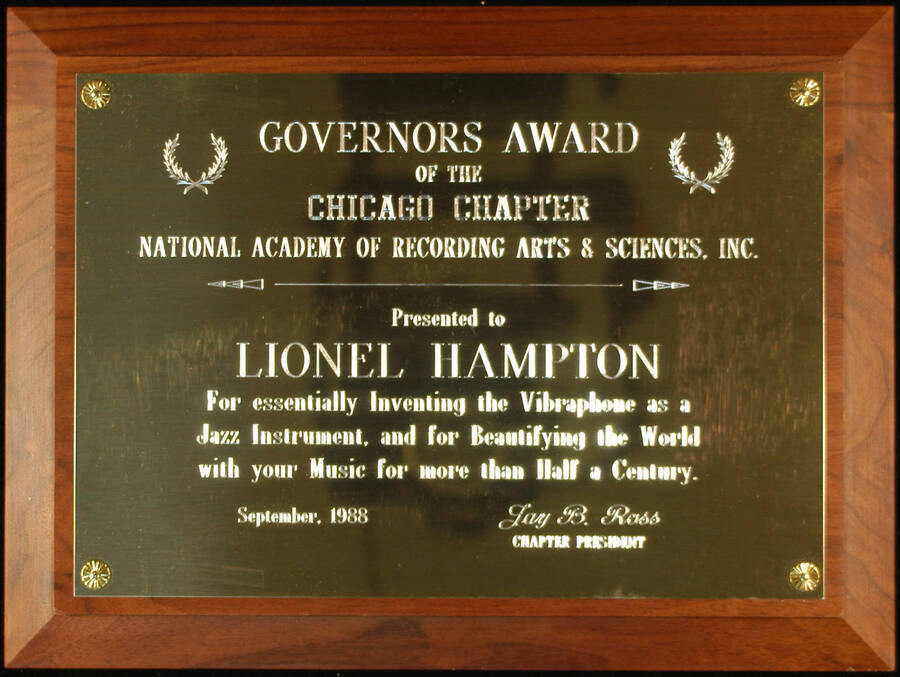 Plaque. 9"x12" Wood finish plaque with engraved plate Governors Award of the Chicago Chapter of National Academy of Recording Arts and Sciences-NARAS presented to Lionel Hampton for inventing the vibraphone as a jazz instrument. Jay B. Ross, Chapter President. Sep. 1988