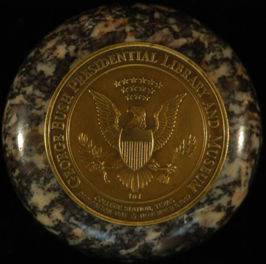 Keepsake Box and Medal. 2 1/8" Stone keepsake box bearing a 1 1/2" bronze medal on top of the lid. The medal depicts the bald eagle with its wings outstretched and the letters "HM" bellow it. The medal bears the inscriptions: "George Bush Presidential Library and Museum" "College Station, Texas" "Dedication Day" "November 6, 1997" and it has reed edges