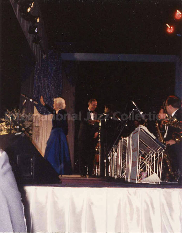 4 1/2 x 3 1/2 inch photograph. George H. W. and Barbara Bush coming on stage in front of Lionel Hampton's orchestra, on the occasion of the Inaugural Ball