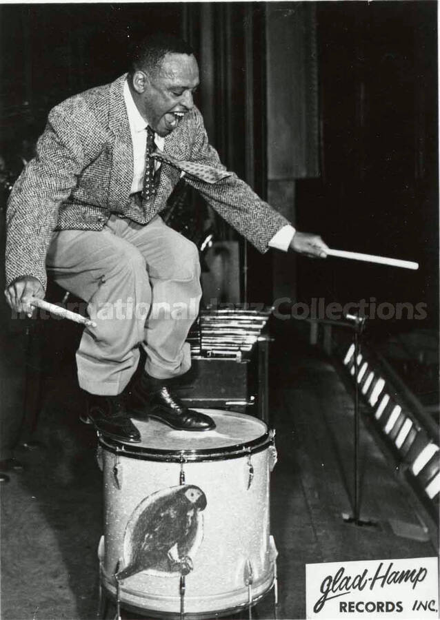 5 1/2 x 3 1/2 inch promotional photograph in the format of postcard. Lionel Hampton. Printed on the back: Lionel Hampton; International Favorite; King of the Vibes, Master of the Drums; Recording Star of Glad-Hamp Records, Inc.; New Album Releases; GLP-1001 The Many Sides of Hamp; GLP-1003 The Exciting Hamp in Europe