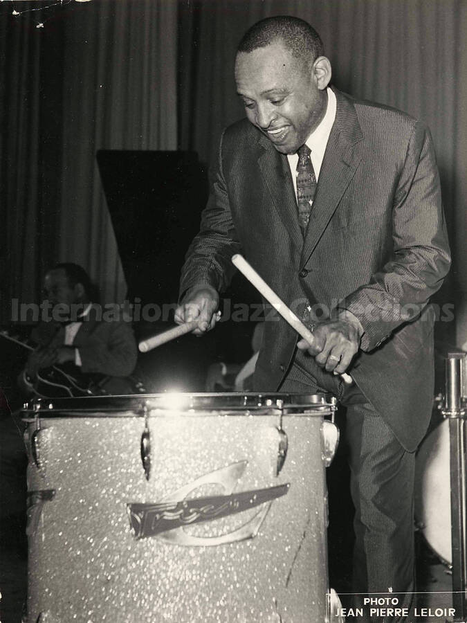 9 1/2 x 7 inch photograph. Lionel Hampton playing Trixon drums. Seen in the background is guitarist Billy Mackel