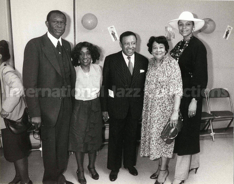 8 x 10 inch photograph. Lionel Hampton poses with unidentified persons on the occasion of his Birthday party