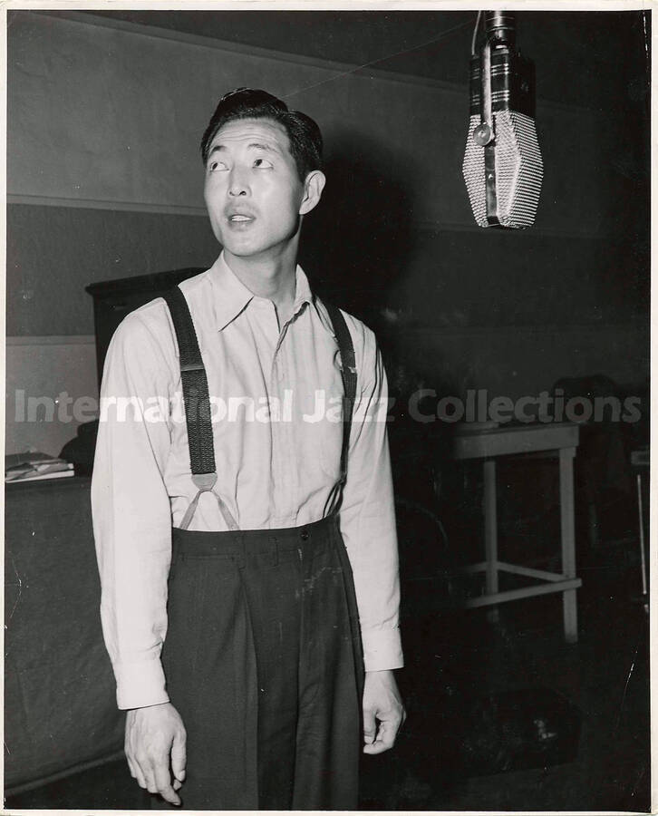 10 x 8 inch photograph. Unidentified man at the microphone