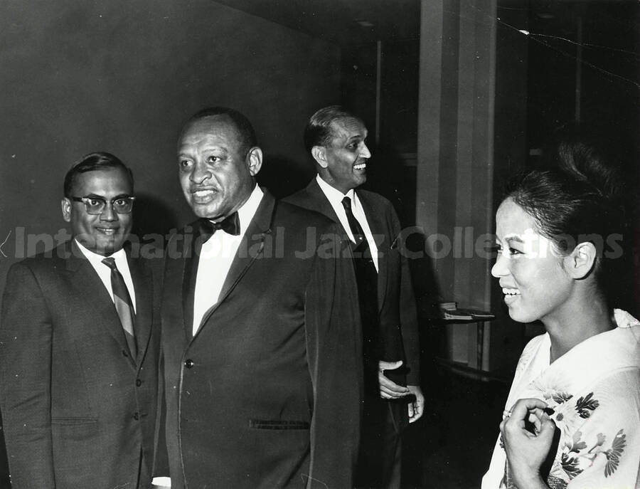 7 x 9 inch photograph. Lionel Hampton with unidentified persons, including a woman dressed in Japanese costume [Yukari Kuroda?]