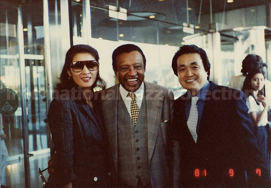3 1/4 x 4 1/2 inch photograph. Lionel Hampton with unidentified woman and man [in Japan?]