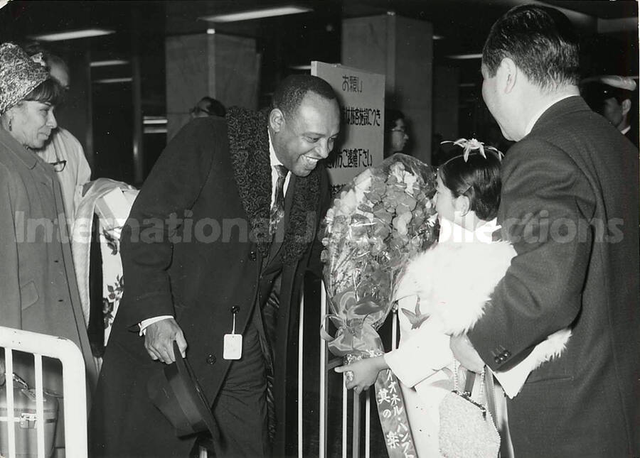 4 1/2 x 6 1/2 inch photograph. Lionel Hampton is welcomed in an airport terminal [in Japan]