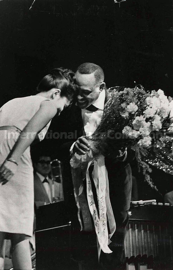 4 1/2 x 6 1/2 inch photograph. Lionel Hampton receives flowers from an unidentified woman [in Japan]