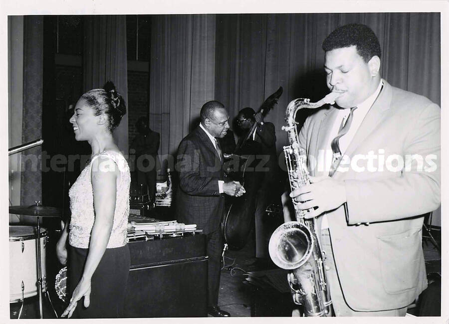 5 x 7 inch photograph. Cannonball Adderley, unidentified singer, and Lionel Hampton, on the occasion Hampton received the Certificate of Distinguished Honorary Alumnus from Langston University. Langston, OK