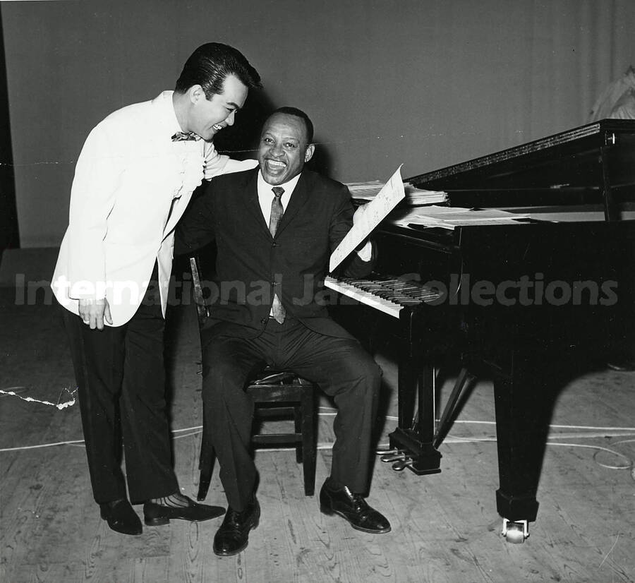 8 x 8 1/2 inch photograph. Lionel Hampton at the piano with unidentified man [in Japan?]