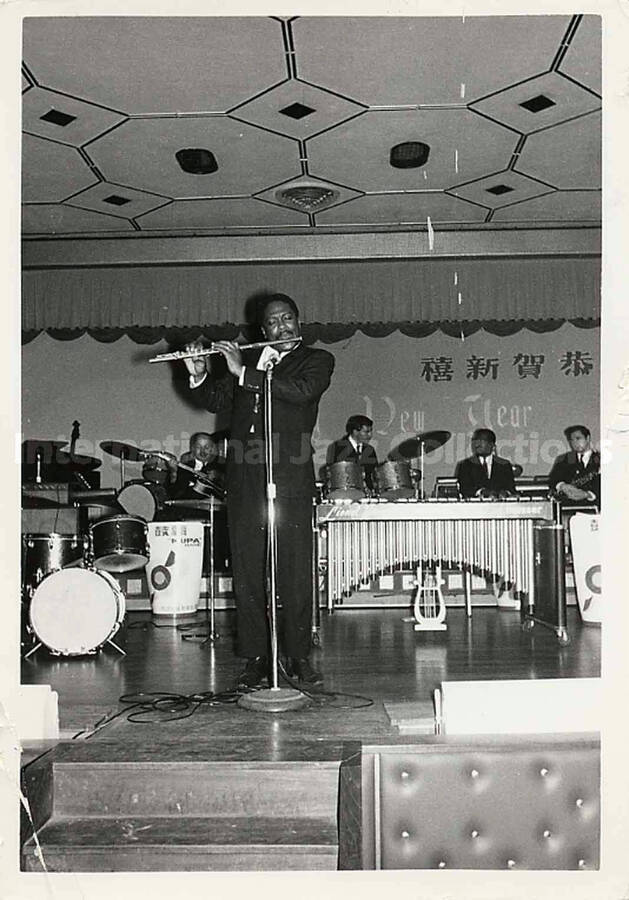 5 x 3 1/2 inch photograph. The Lionel Hampton's band in Japan, with unidentified flute player out front