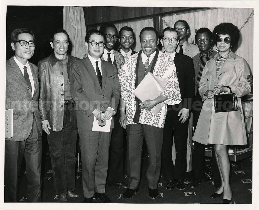 8 x 10 inch photograph. Lionel Hampton with unidentified persons in Tokyo, Japan. Leo Moore is behind Lionel Hampton