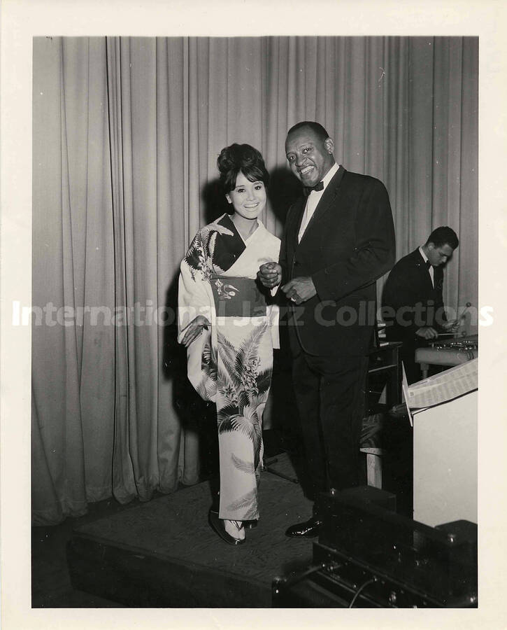 10 x 8 inch photograph. Lionel Hampton with unidentified woman dressed in Japanese costume [Miyoko Hoshino?]