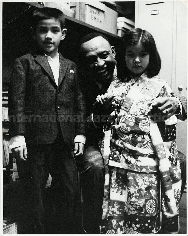 10 x 8 inch photograph. Lionel Hampton with a girl dressed in Japanese costume and a boy [in Japan?]