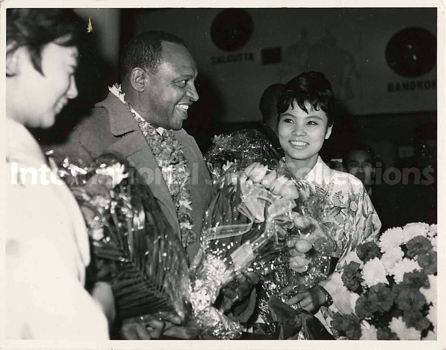 4 x 5 inch photograph. Lionel Hampton is welcomed with flowers in an airport terminal [in Japan]