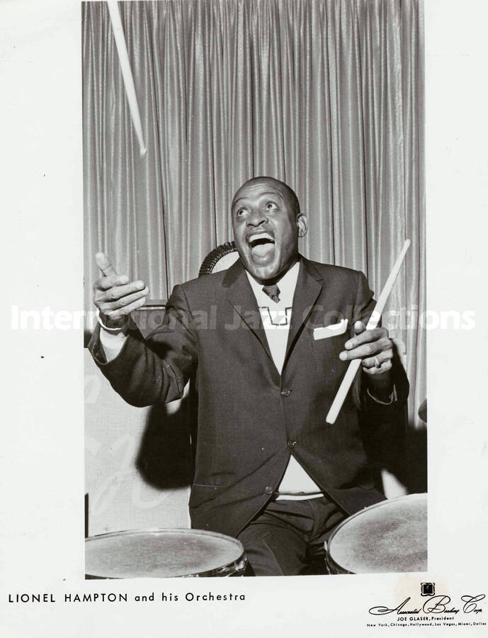 10 x 8 inch promotional photograph. Lionel Hampton playing the drums. Inscribed at the bottom of the photograph: Lionel Hampton and his Orchestra