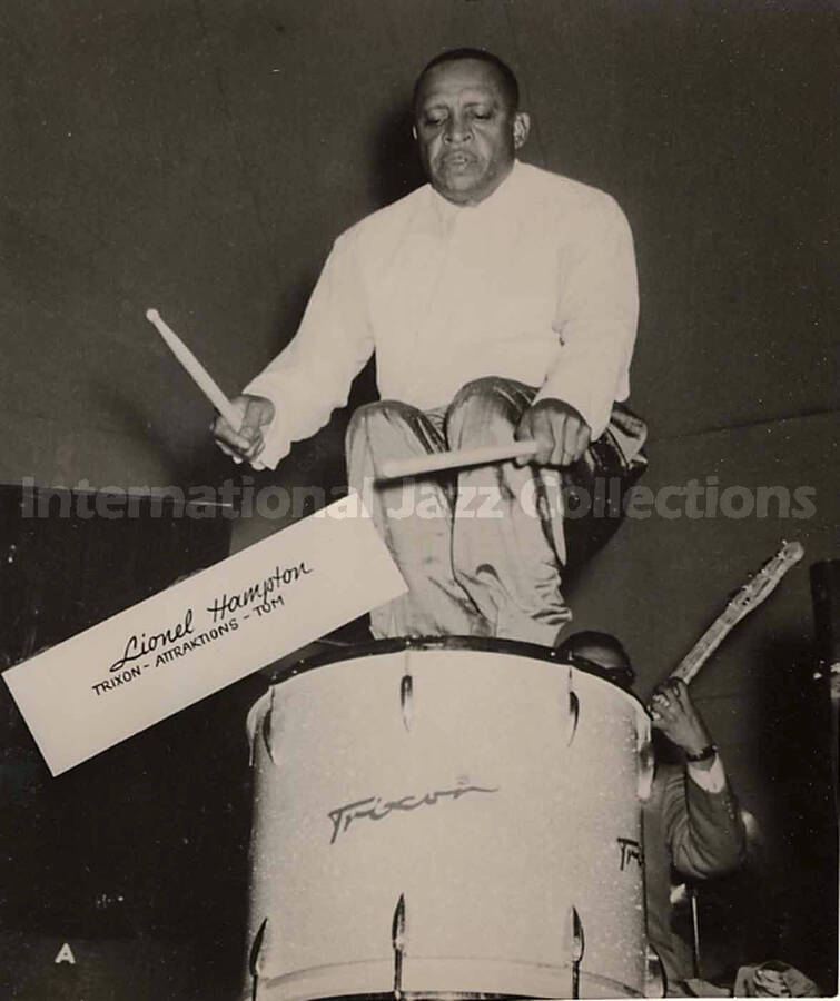 4 3/4 x4 inch photograph in the format of postcard. Lionel Hampton playing the drums, [in Germany?]. Inscribed on the photograph: Lionel Hampton; Trixon-Attraktions-Tom
