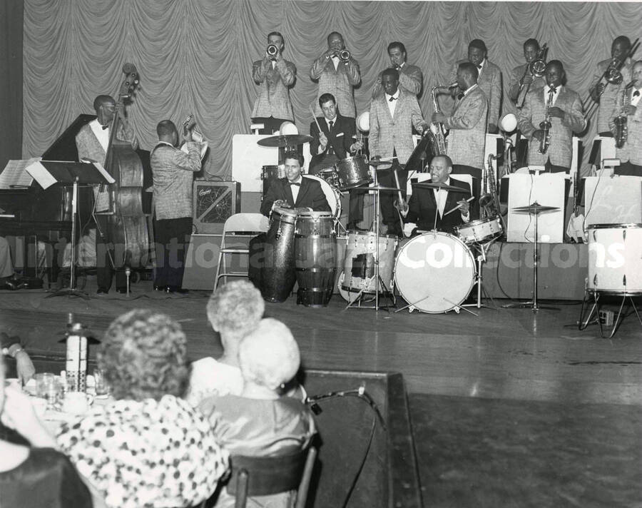 8 x 10 inch photograph. Lionel Hampton, Jerry Lewis, and orchestra perform for an audience