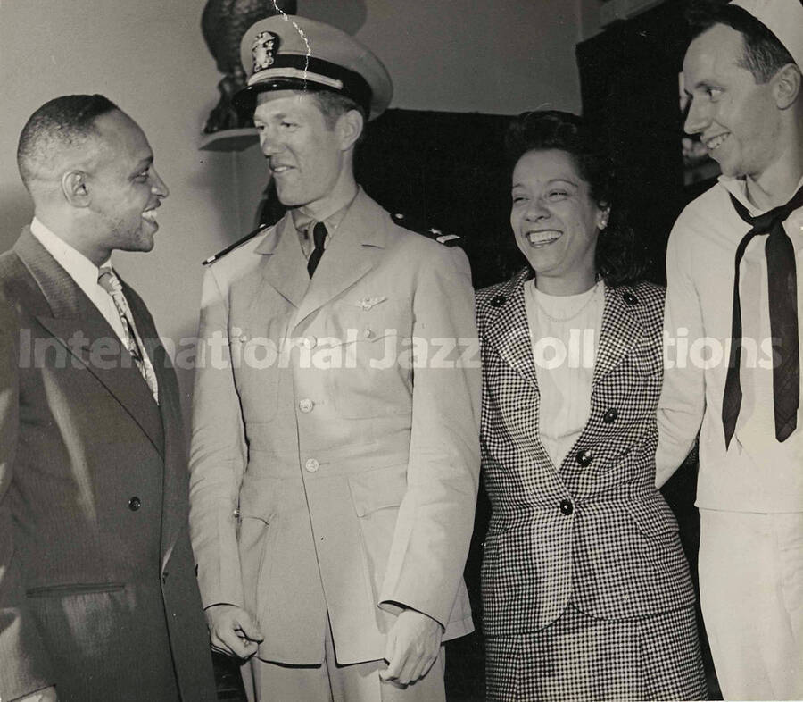 7 1/2 x 8 1/2 inch photograph. Gladys and Lionel Hampton with two unidentified military personnel