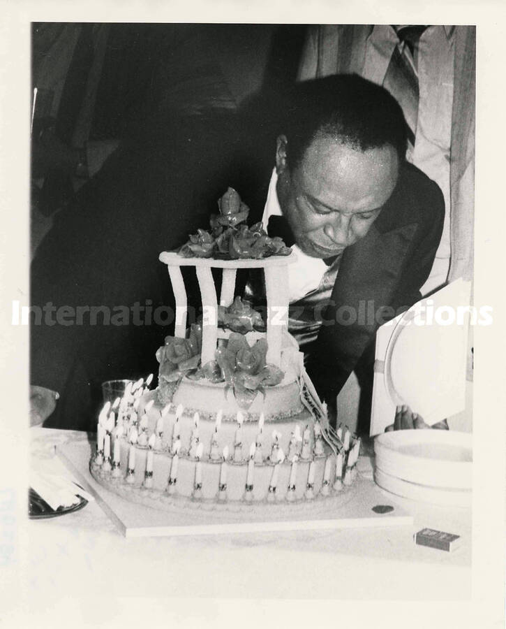 8 x 10 inch photograph. Lionel Hampton blowing out the candles of a [birthday?] cake