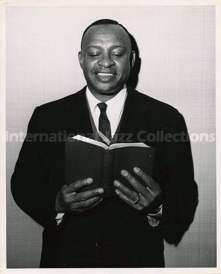 10 x 8 inch photograph. Lionel Hampton reading the Holy Bible