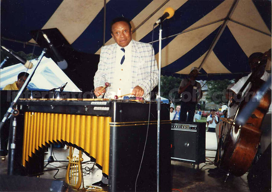 3 1/2 x 5 inch photograph. Lionel Hampton playing the vibraphone under a tent, on the occasion of the Jazzy [Summer jazz festival in Yonkers, NY?]