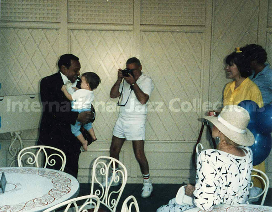 3 1/2 x 4 1/2 inch photograph. Lionel Hampton holding a child, at Disneyland