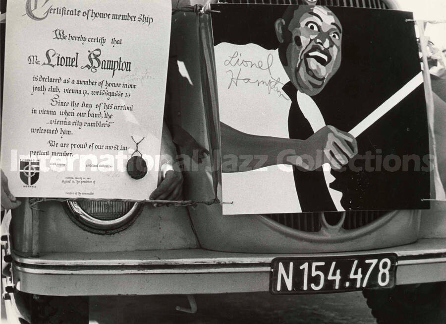 7 x 9 1/2 inch photograph. The Certificate of Honor Membership from the Vienna City Ramblers Band to Lionel Hampton and his picture attached to the front of a car