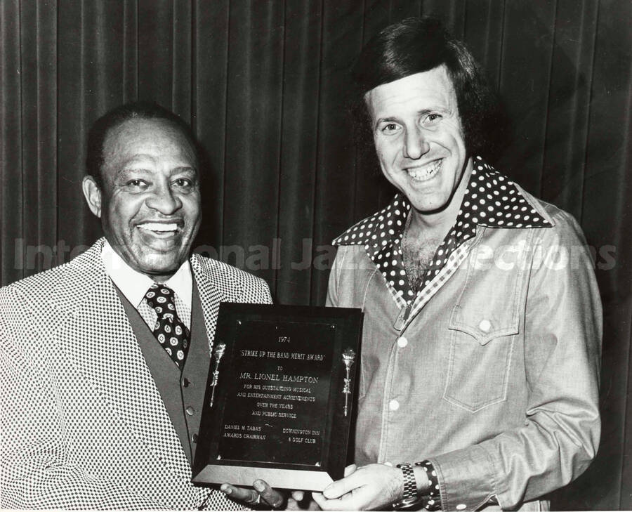 8 x 10 inch photograph. Lionel Hampton receives the first annual Strike Up the Band Achievement Award from Paul Jonas, Entertainment Director of Downingtown Inn, Downingtown, PA. This photograph is accompanied by a caption note