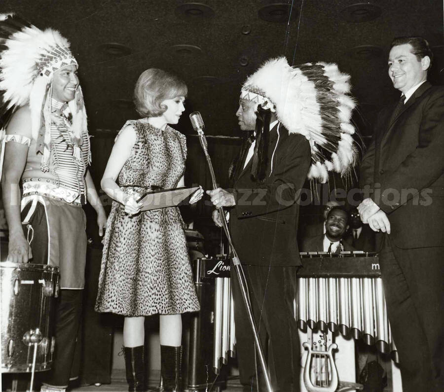 6 1/2 x 7 inch photograph. Edie Adams makes Lionel Hampton an honorary Indian Chief