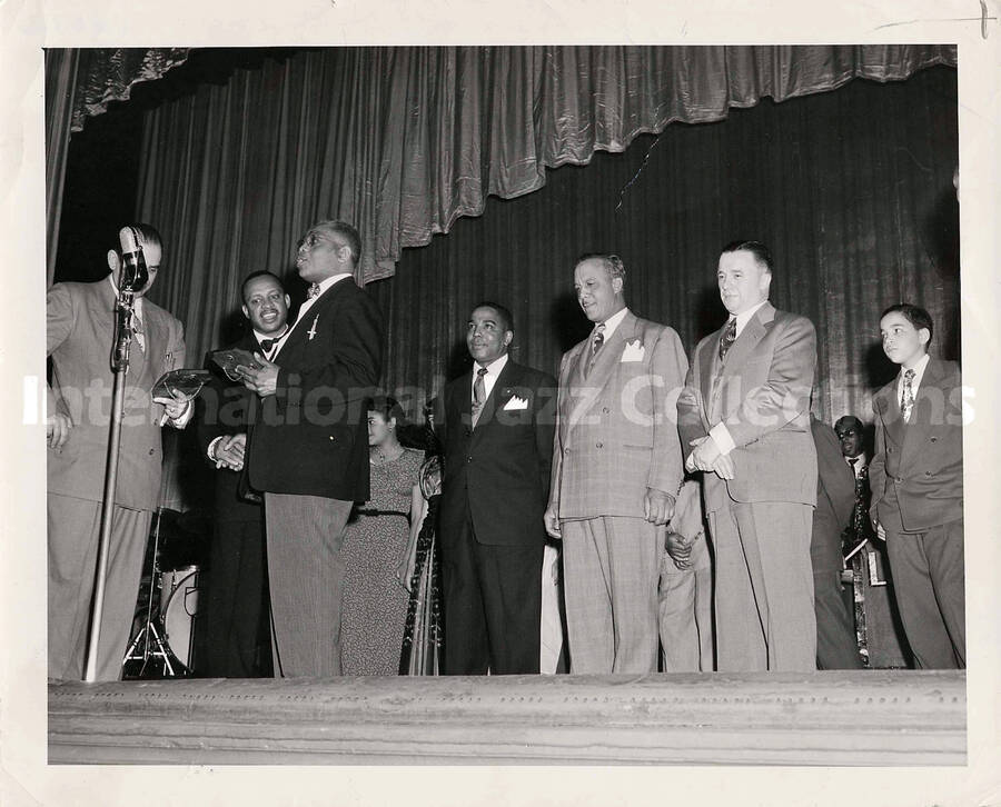 8 x 10 inch photograph. Lionel Hampton with unidentified men holding plaques