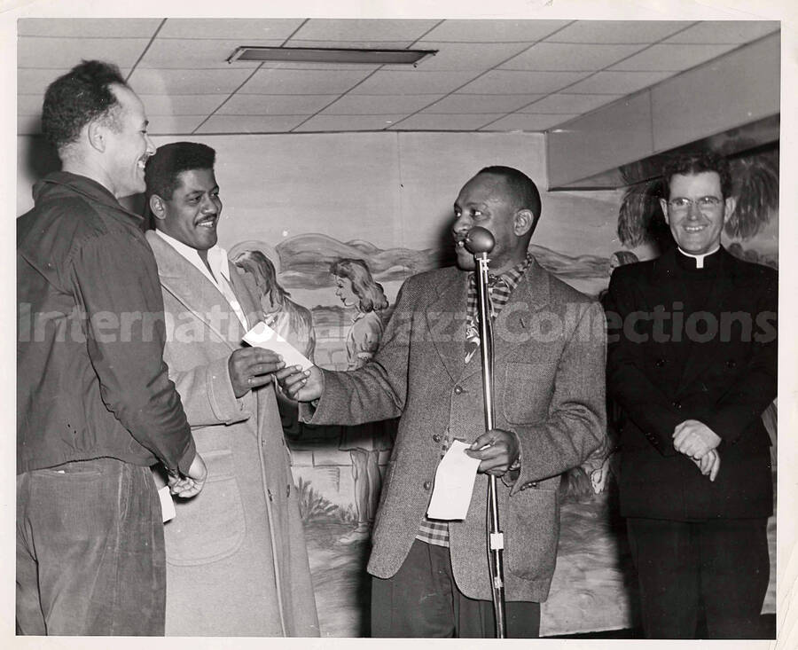 8 x 10 inch photograph. Lionel Hampton with three unidentified men, including a religious