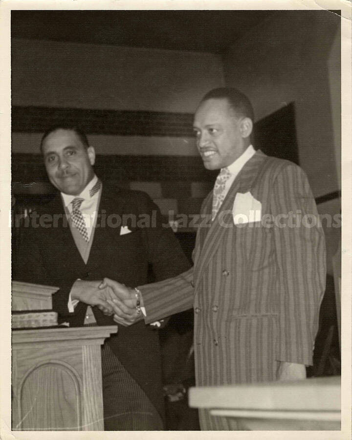 10 x 8 inch photograph. Lionel Hampton shakes hand with unidentified man