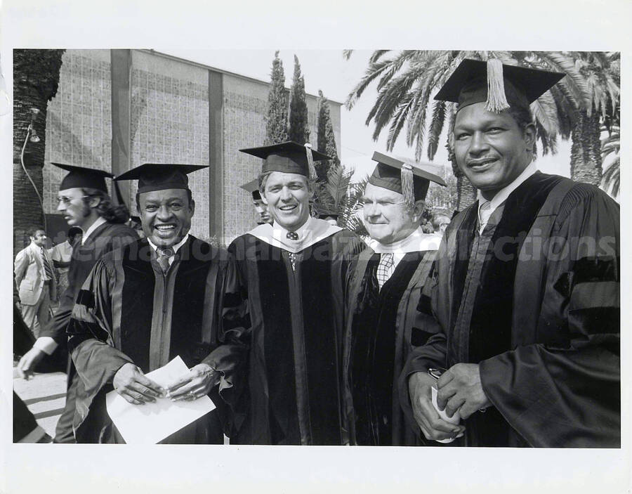 8 x 10 inch photograph. Lionel Hampton receives a honorary degree from Pepperdine University. Tom Bradley, Los Angeles Mayor, is on the right